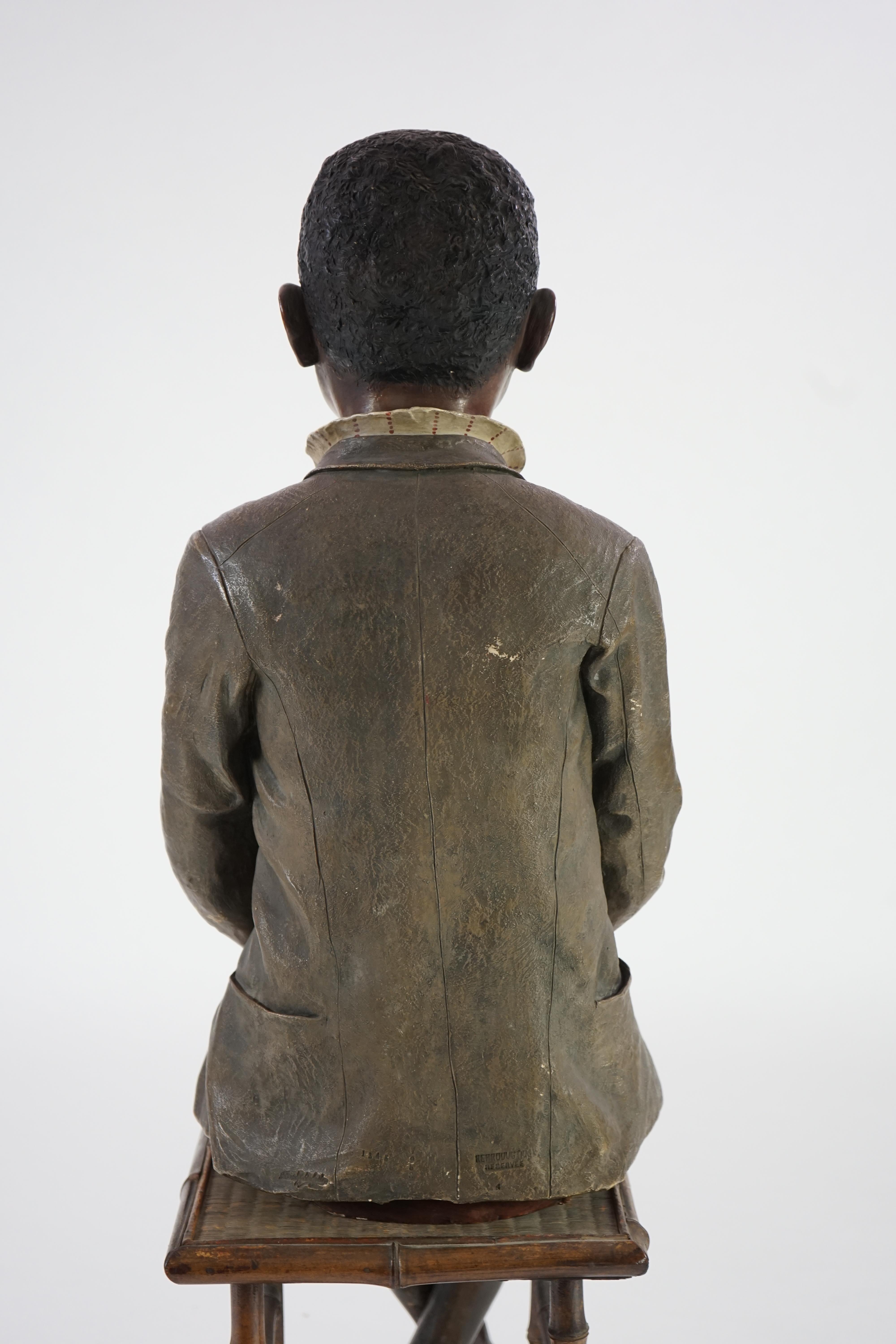 A late 19th century Friedrich Goldscheider life size cold painted terracotta figure of a black boy